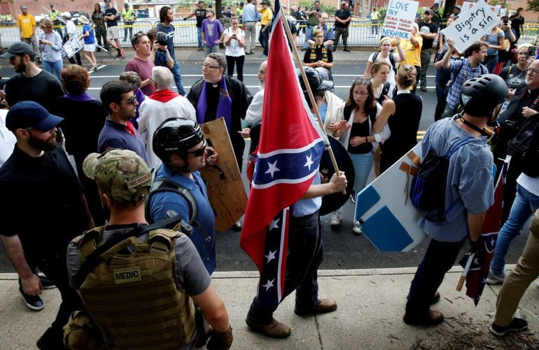 Un supremacista blanco cargando con una bandera confederada momentos antes de la manifestación convocada en Charlottesville, Virginia.