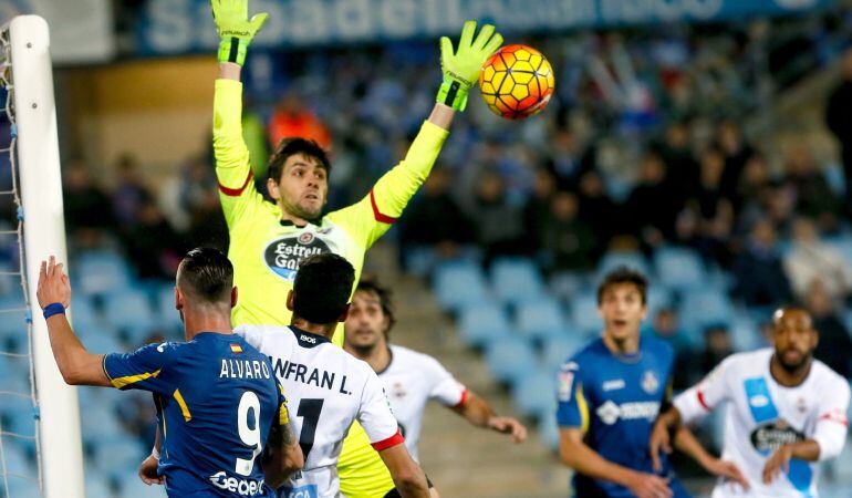 El portero argentino del Deportivo Germán Lux (2i, detrás) intenta atrapar el balón ante el delantero del Getafe Álvaro Vázquez, en partido de la decimoséptima jornada de liga en Primera División que se disputa esta noche en el Coliseo Alfonso Pérez. 