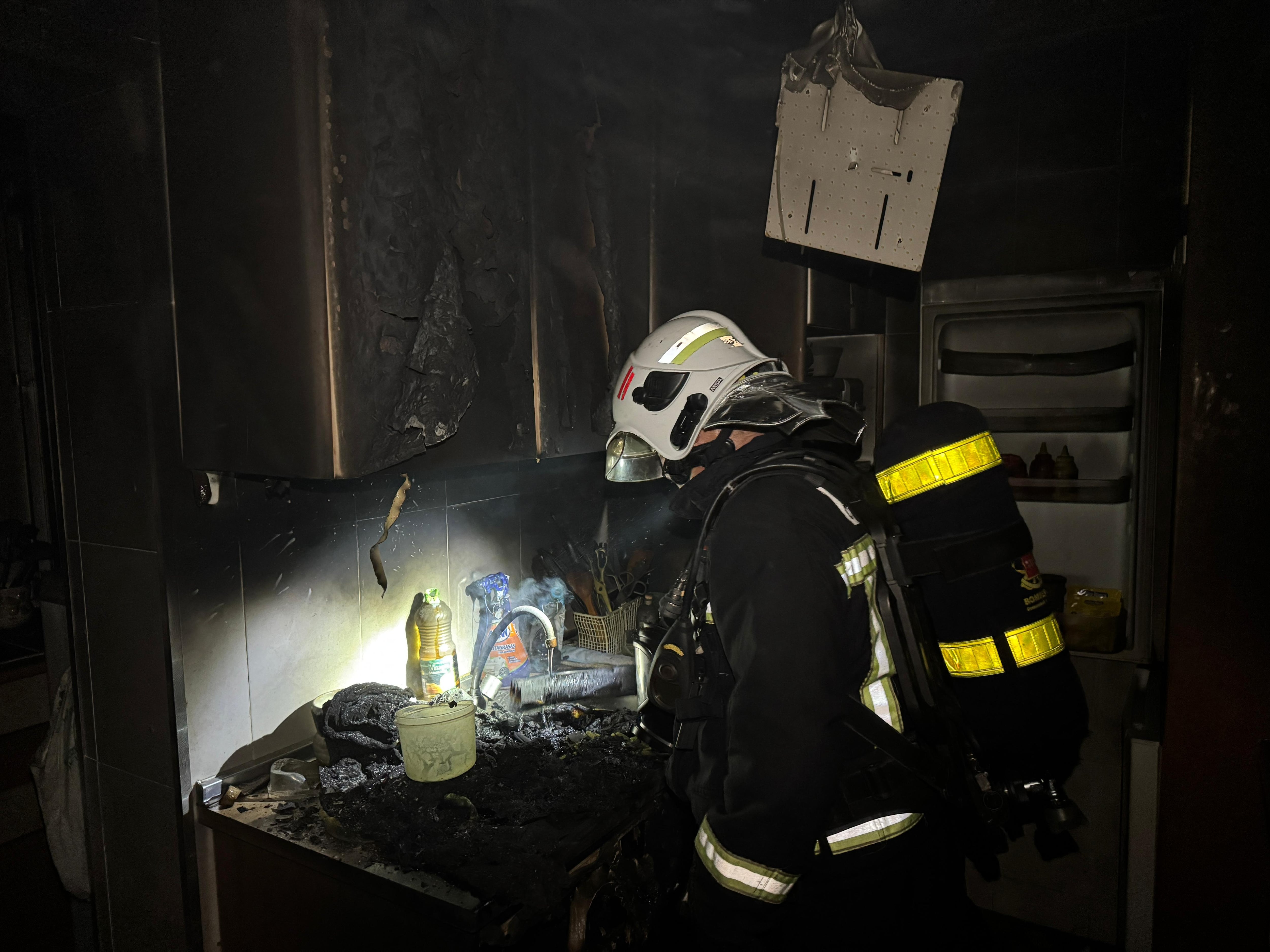 Los bomberos de la Comunidad de Madrid inspeccionan la cocina, donde se detectó uno de los focos del incendio.