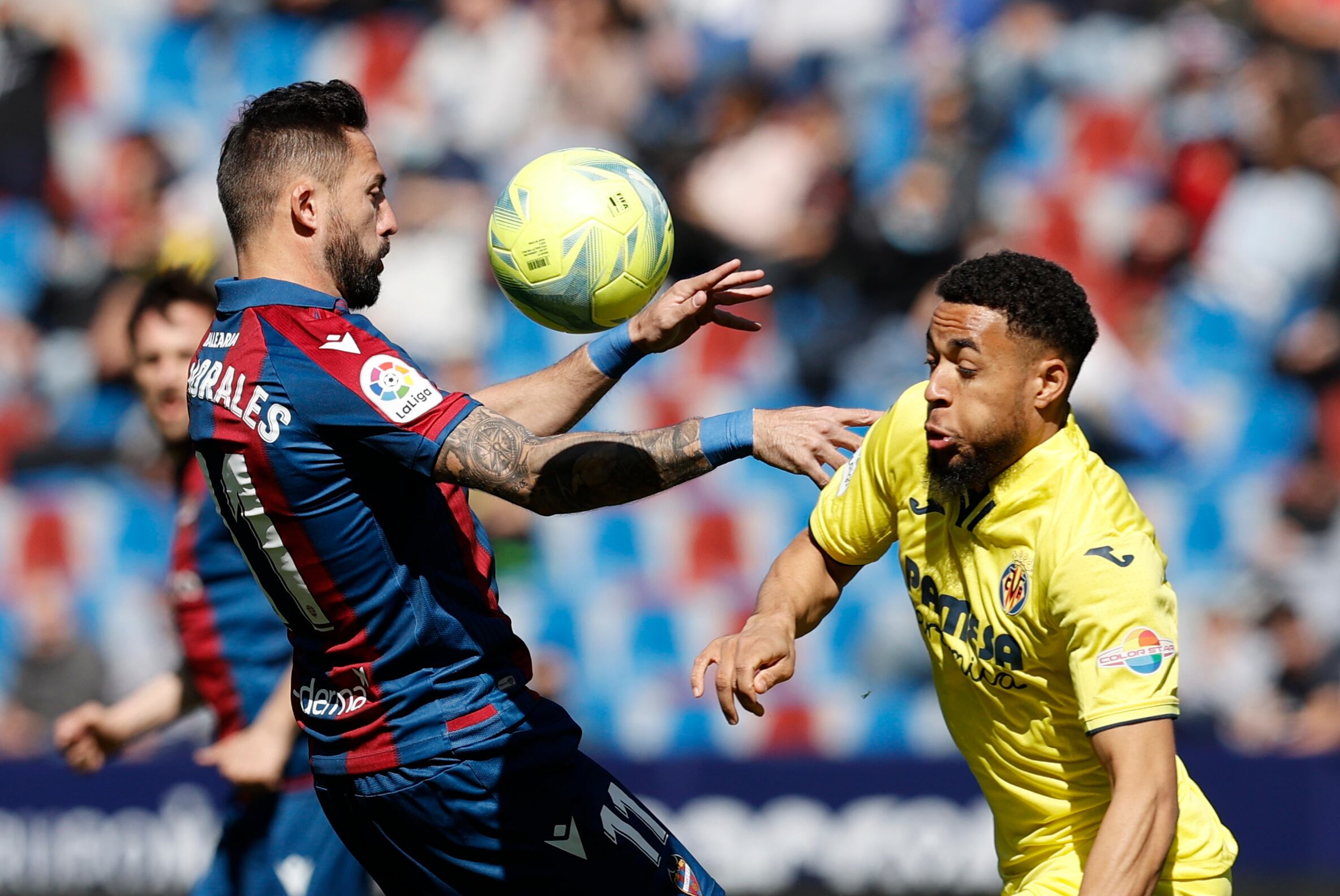 VALENCIA, 02/04/2022.- El centrocampista del Levante UD, José Luis Morales (i), intenta controlar el balón ante el delantero neerlandés del Villarreal, Arnaut Danjuma, durante el encuentro correspondiente a la jornada 30 de primera división disputado hoy sábado en el Ciutat de Valencia. EFE / Kai Forsterling.
