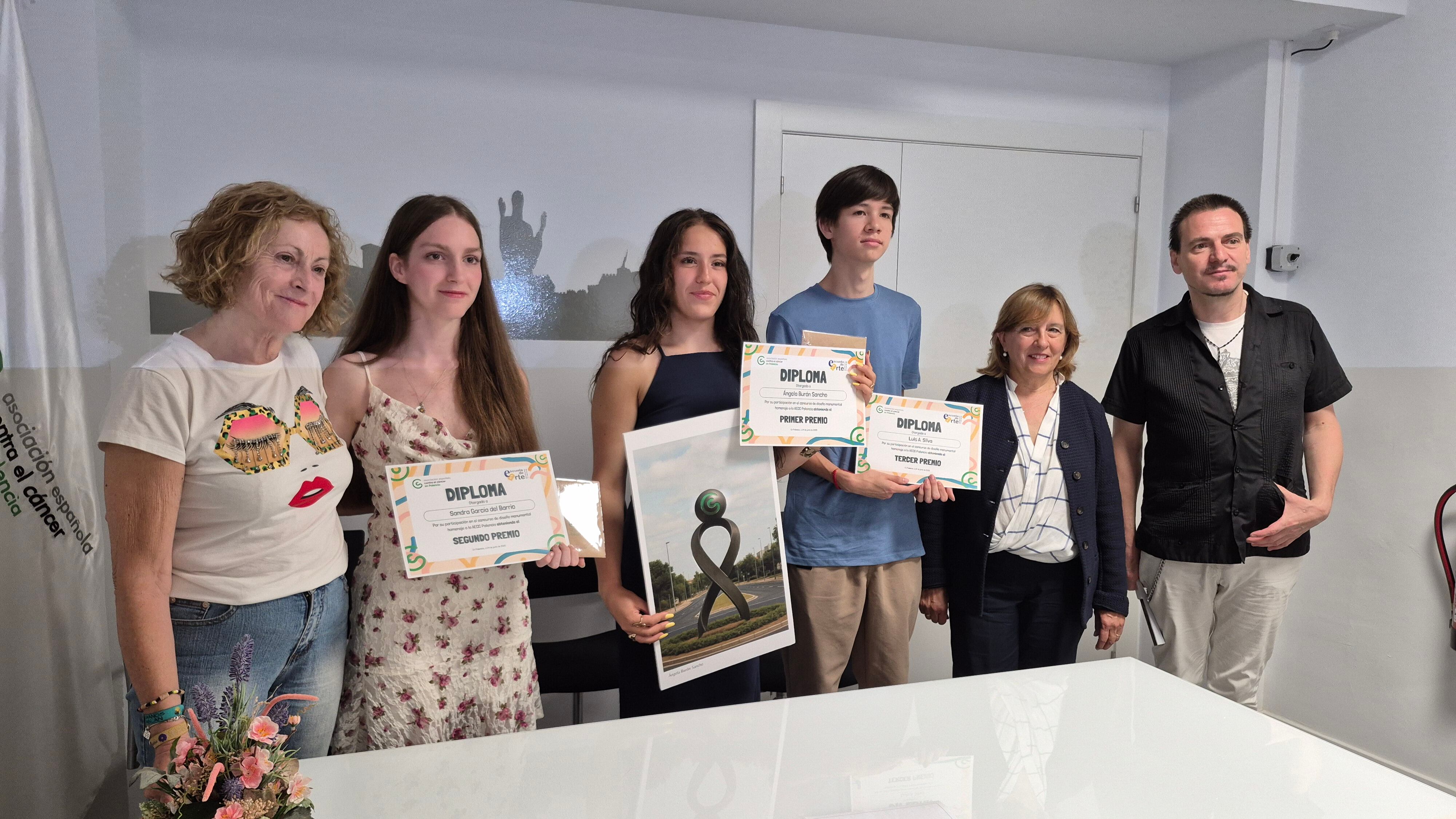 Ángela Burón (tercera por la izquierda) firma la escultura en reconocimiento a AECC Palencia que ocupará la rotonda junto al hospital