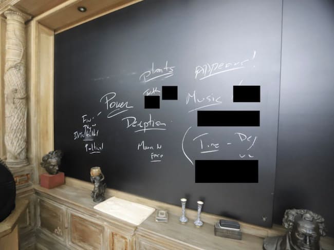 Una pizarra en la pared de una de las habitaciones tiene palabras garabateadas como "poder"