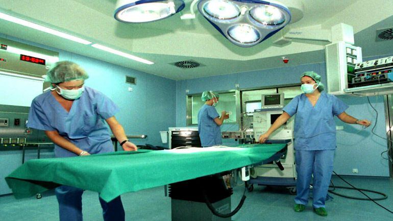 Personal sanitario prepara un quirófano para una intervención.