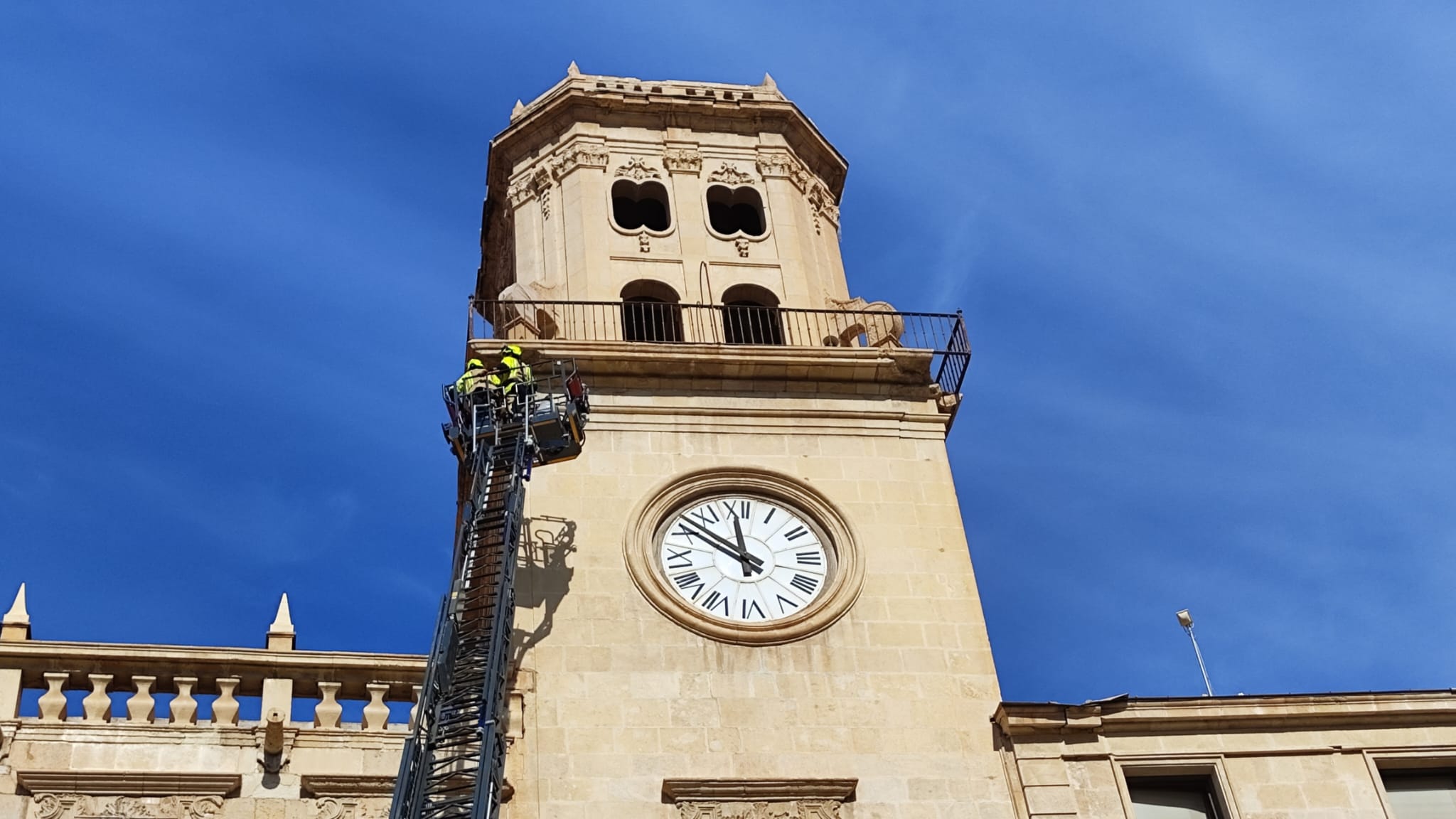 Bomberos del SEPEIS revisando la torre del reloj del Ayuntamiento de Alicante para evitar nuevos desprendimientos