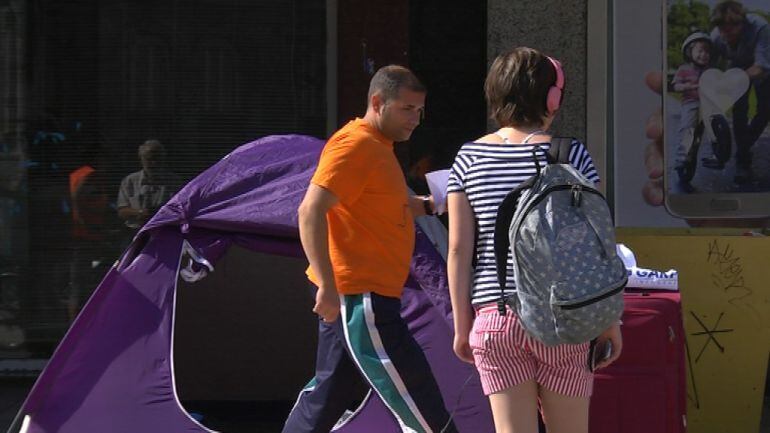 José Antonio repartiendo panfletos con su historia delante de la tienda en la que está acampado