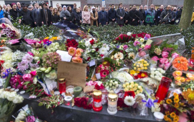 Varias personas depositan flores y muestran sus condolencias en un homenaje a las víctimas de los ataques terroristas de París.