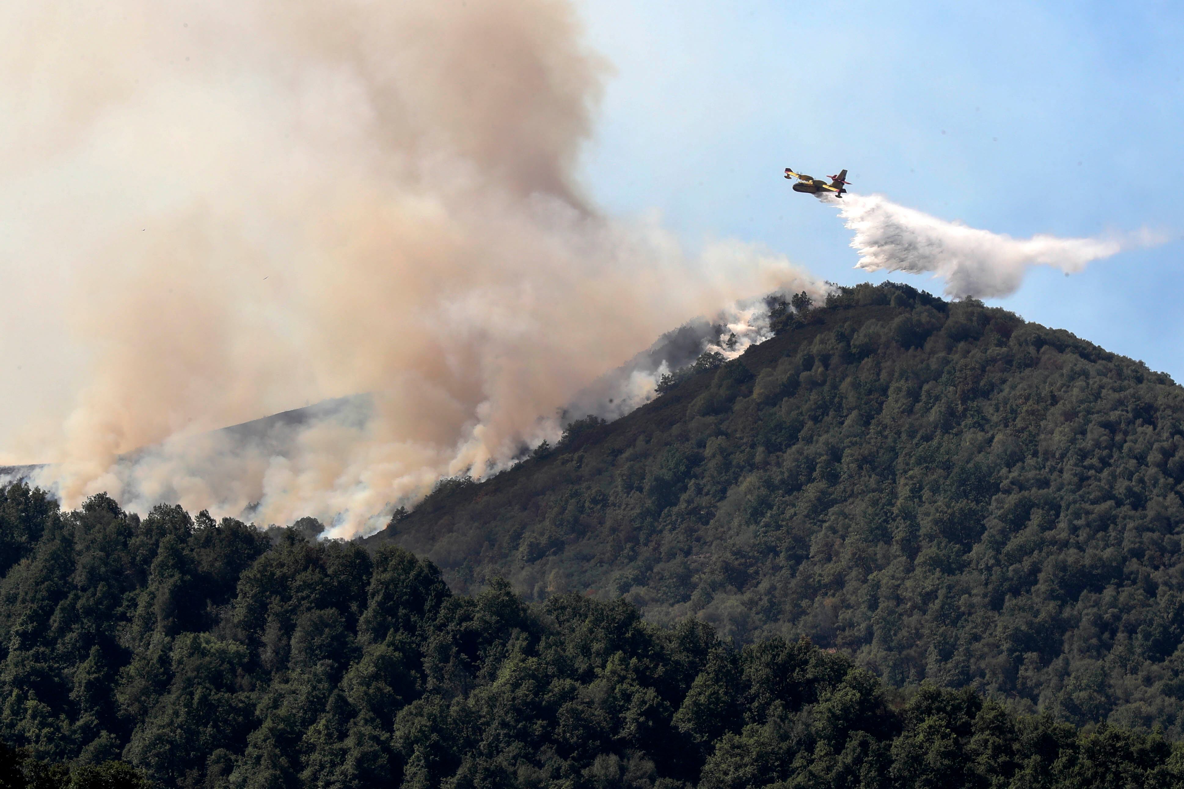 Un avión contra incendios trabaja en la zona de Degaña, próxima a la reserva de biosfera del bosque de Muniellos, durante la visita del presidente del Gobierno, Pedro Sánchez al Puesto de Mando Avanzado de Degaña (Asturias)