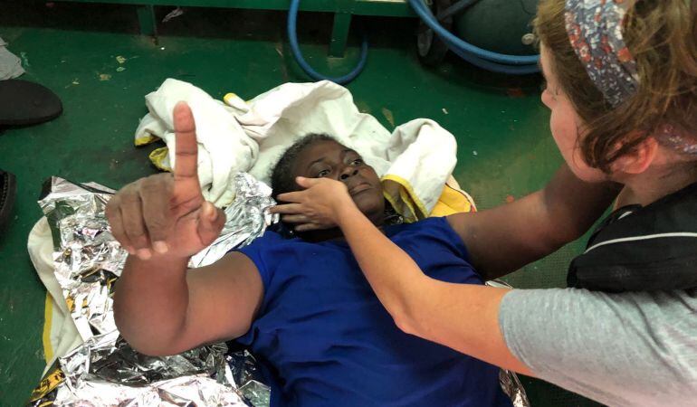 Fotografía facilitada por la ONG española Proactiva Open Arms de la superviviente rescatada ayer en una embarcación naufragada en la que también se encontró el cadáver de una mujer y de un niño de corta edad.