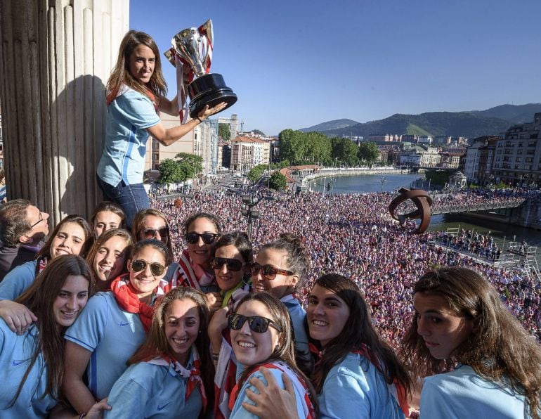 Iraia Iturregi, capitana del Athletic Club muestra la copa que acredita al equipo vencedor de la Liga de fútbol femenina, junto a sus compañeras en el balcón del Ayuntamiento de Bilbao donde han sido recibidas por el alcalde bilbaíno