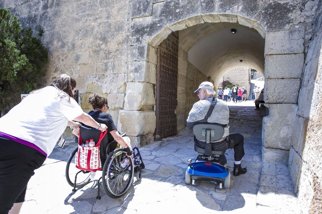 Turistas mayores acceden al Castillo de Santa Bárbara durante una excursión.