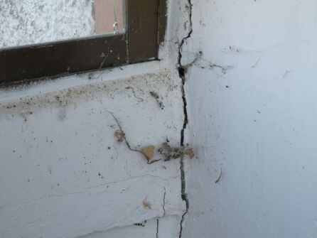 Detalle de las grietas en la fachada exterior de la casa.