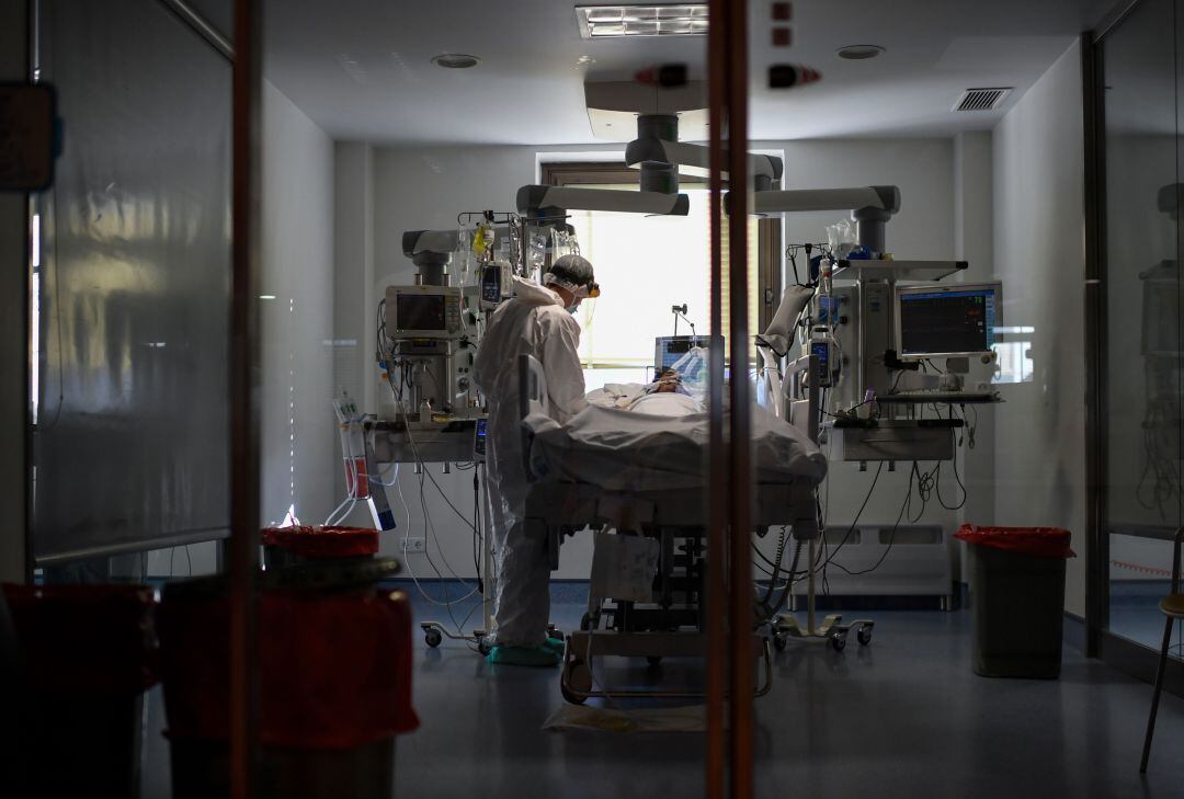 Personal sanitario atendiendo a un paciente de COVID-19 en la UCI.