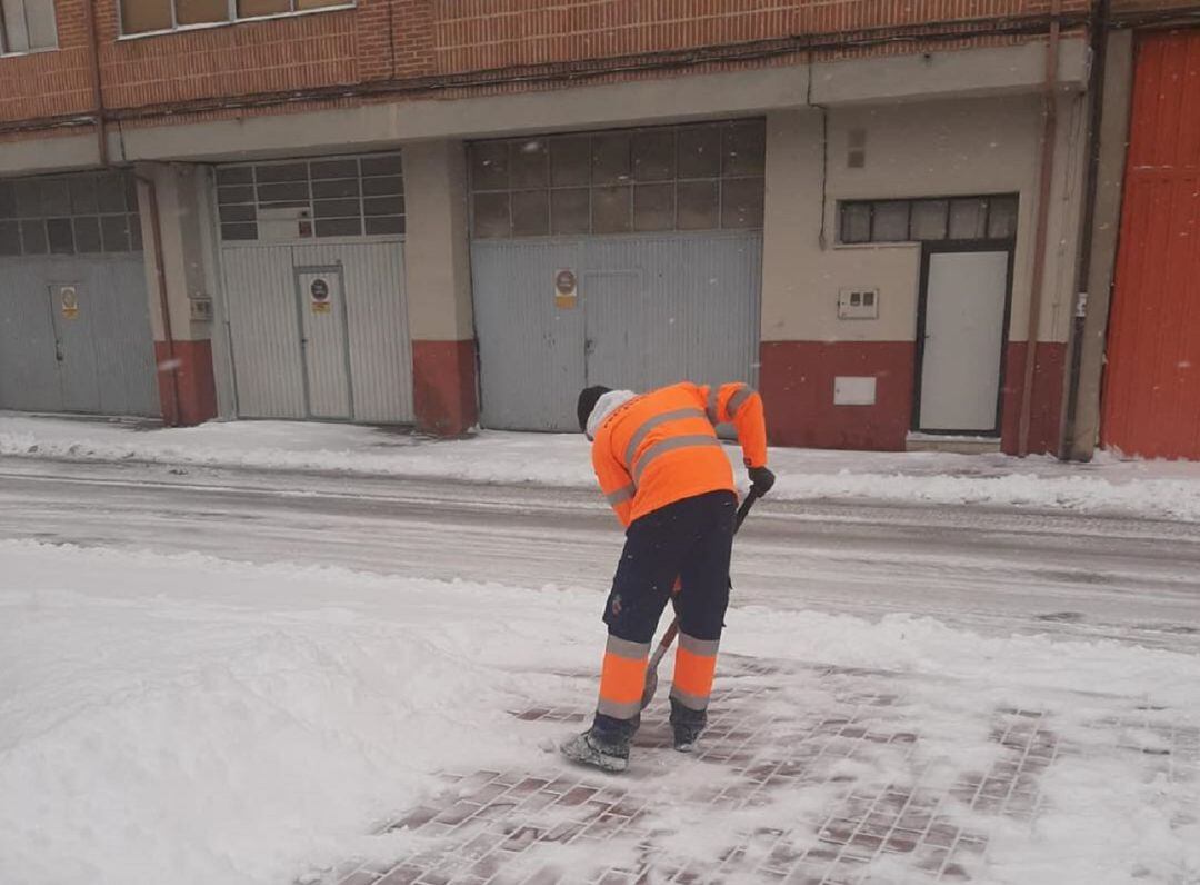 Un voluntario limpia una de las aceras de Peñafiel