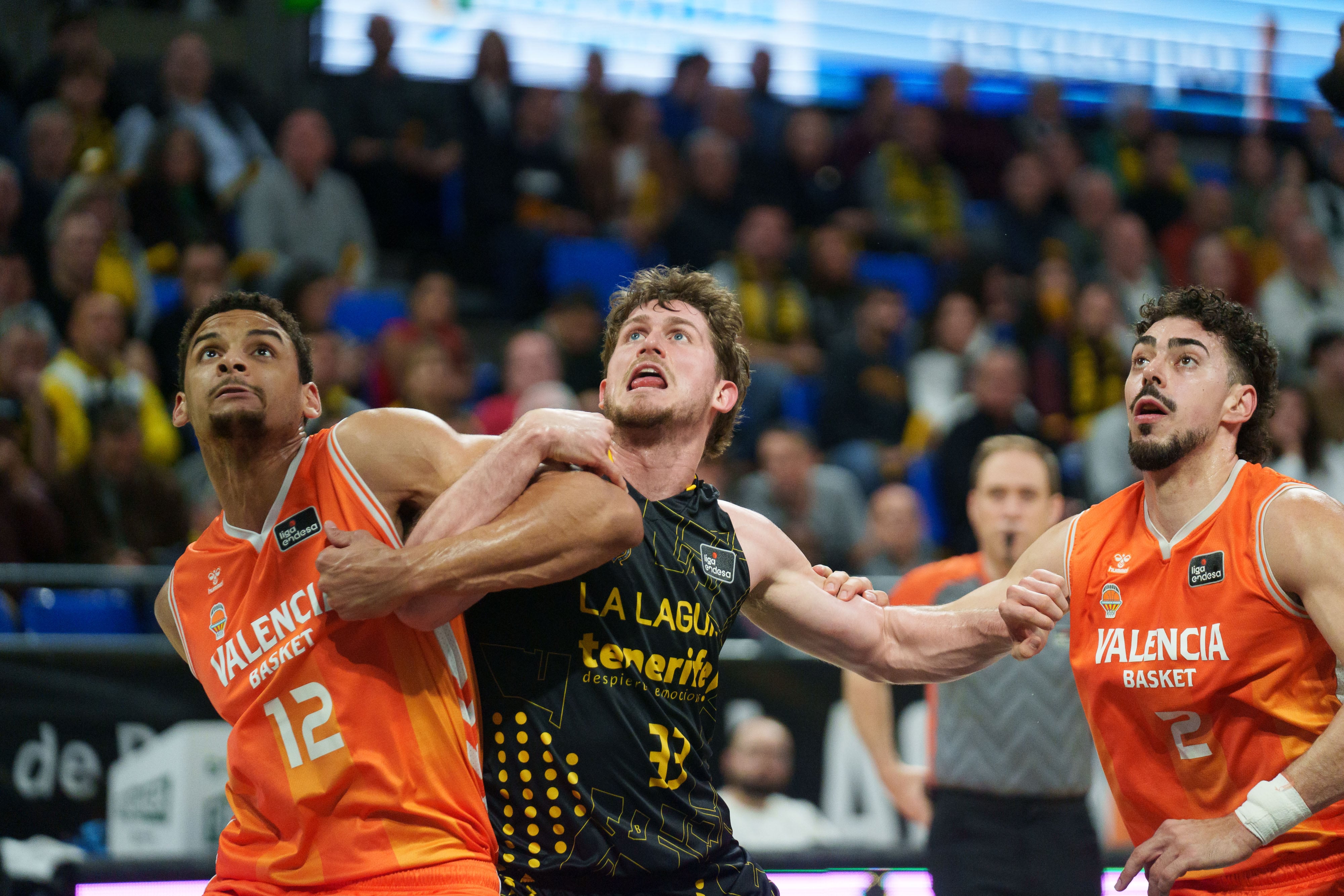 TENERIFE, 14/03/2026.- El alero del La Laguna Tenerife Héctor Alderete (c) ante el pívot del Valencia Basket, Neal Sako (i) y el alero del Valencia Basket, Josep Puerto (i) durante el partido correspondiente a la Liga Endesa que se celebra este sábado en el Pabellón Santiago Martín de La Laguna (Tenerife), entre el La Laguna Tenerife y el Valencia Basket. EFE/Ramón de la Rocha