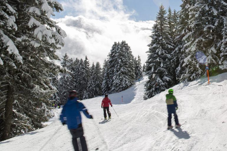 Esquiadores disfrutan de la nieve y el sol en la estación en los Alpes