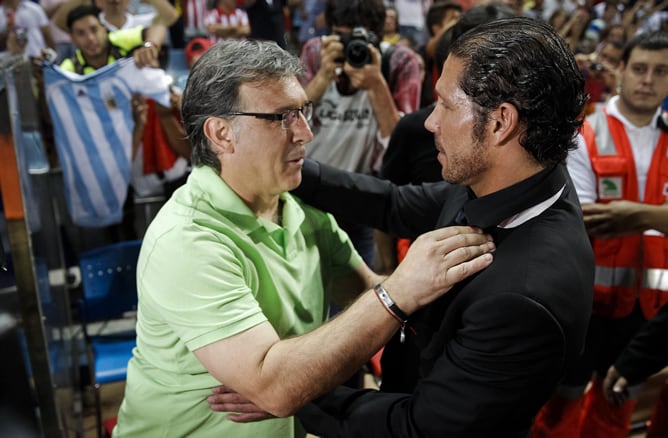 Los entrenadores argentinos Diego Simeone (d), del Atlético de Madrid, y Gerardo Tata Martino, del FC Barcelona, al inicio del partido de ida de la Supercopa