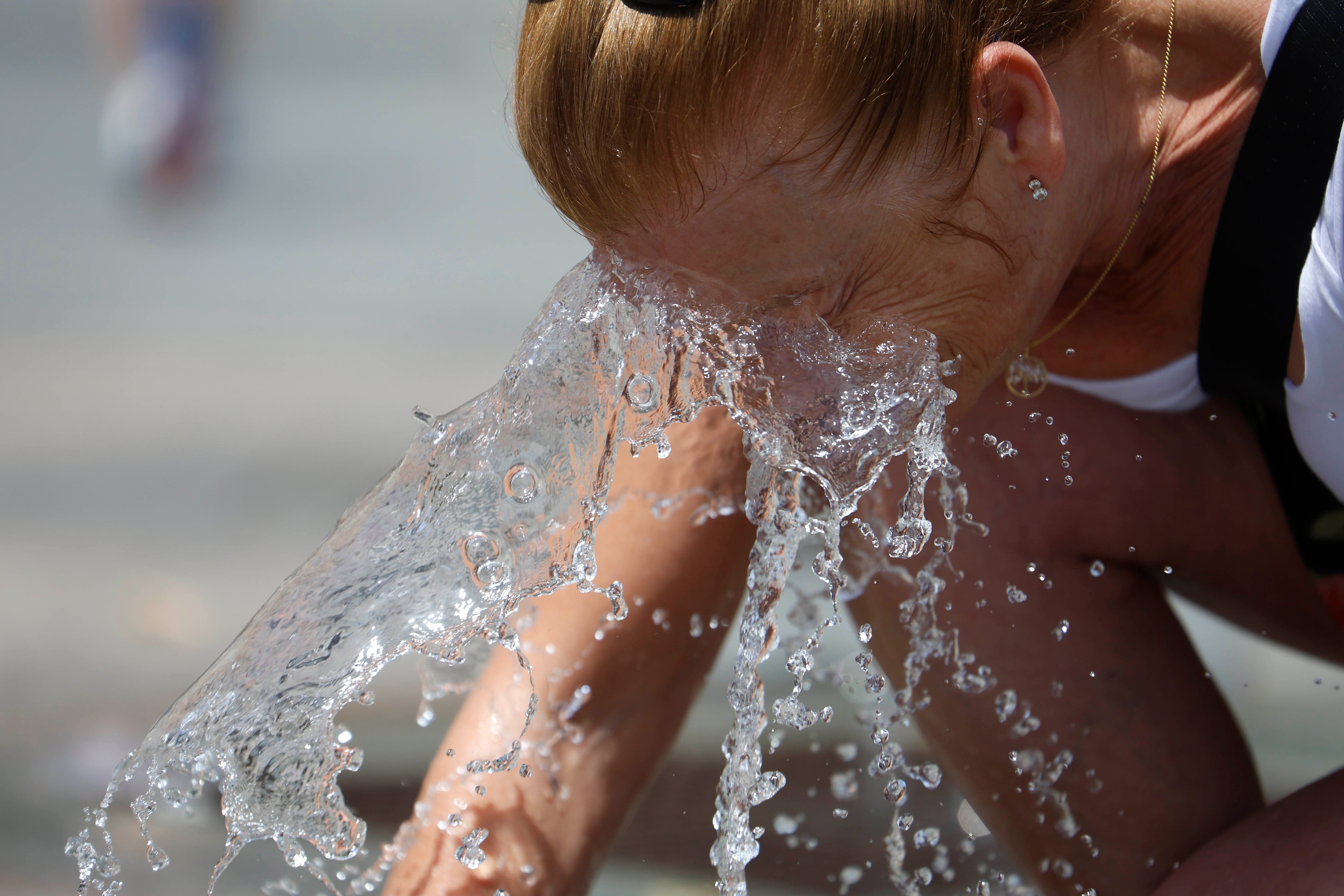 Una mujer se refresca en una de las fuentes del centro de Córdoba. EFE/Salas. 