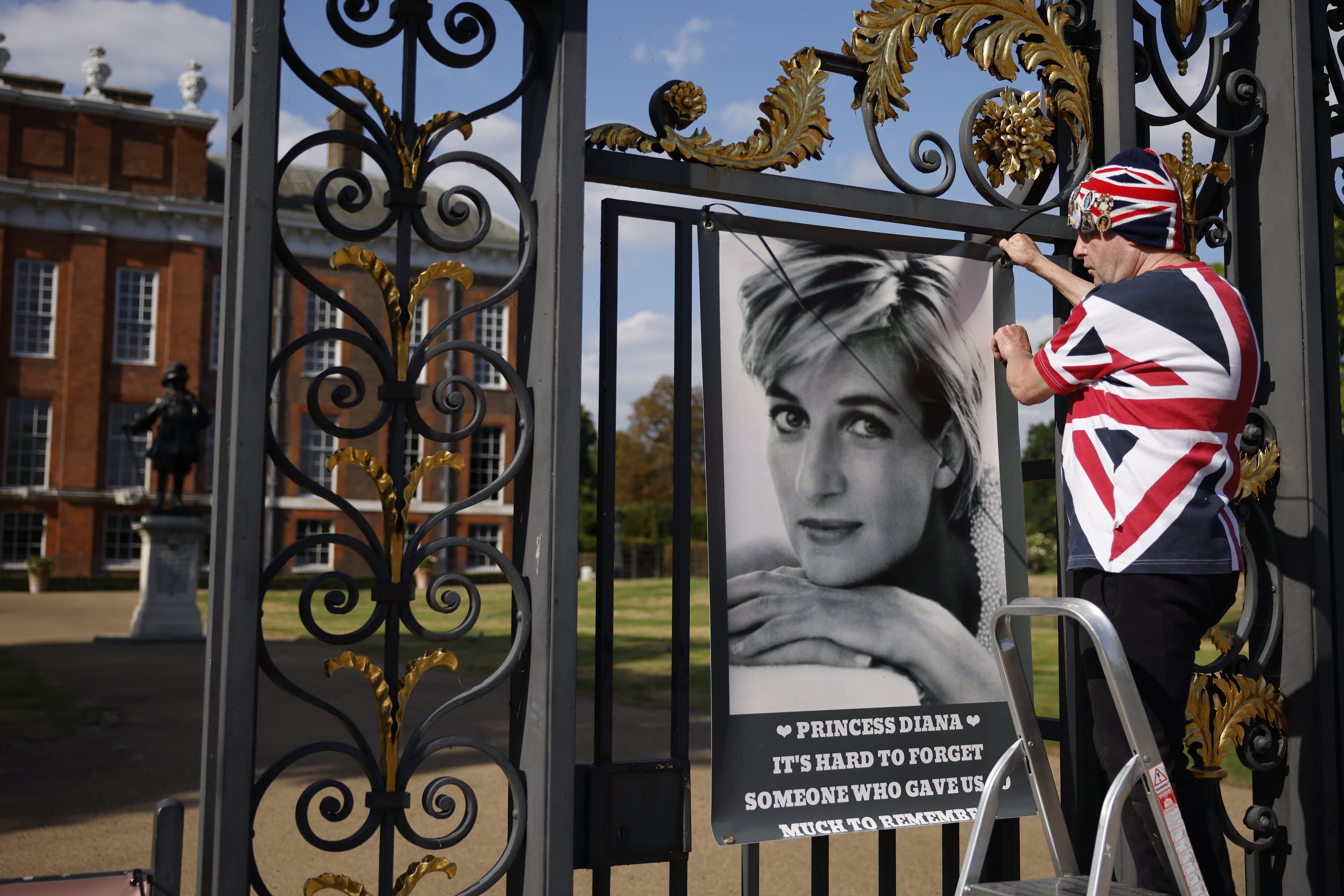 John Loughrey, superfan de Diana, cuelga un cartel de Diana en las puertas del Palacio de Kensington en Londres, Gran Bretaña, el 26 de agosto de 2022. Diana, Princesa de Gales, murió en París, Francia, el 31 de agosto de 1997.