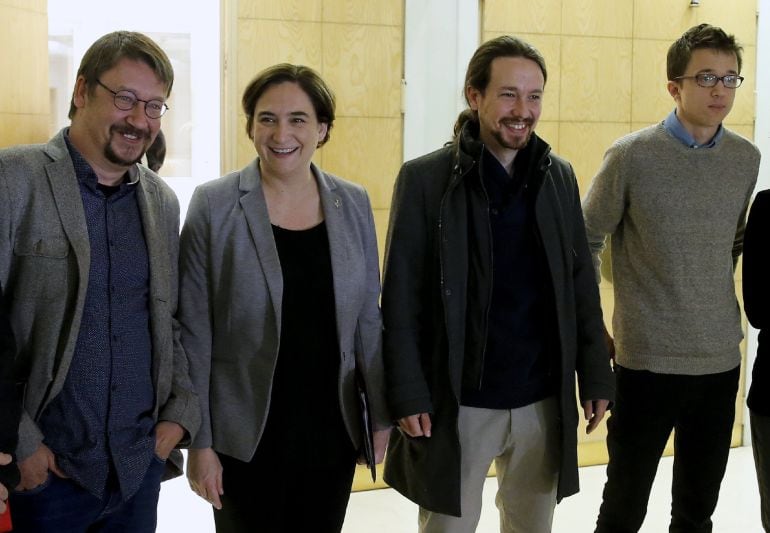 La alcaldesa de Barcelona, Ada Colau, posa con el líder de Podemos, Pablo Iglesias (2-d); el portavoz en el Congreso de la formación, Ínigo Errejón (d), y el portavoz de En Comú Podem, Xavier Domènech, a su llegada al desayuno informativo en el que ha ofr