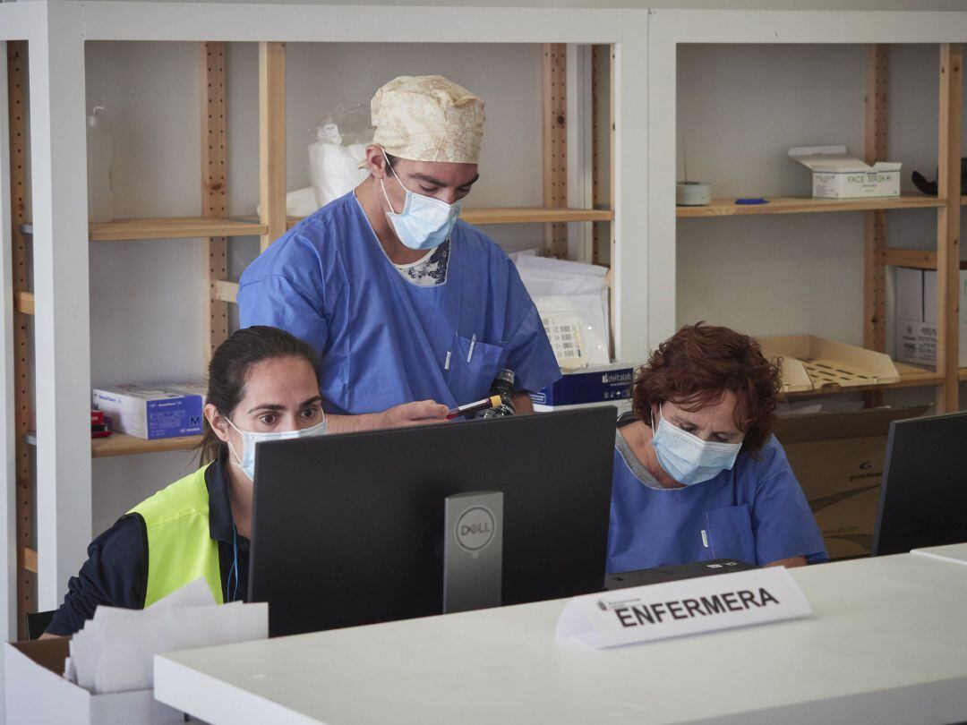 Imagen de archivo de trabajadores sanitarios que atienden a los pacientes que acuden para realizarse una extracción de muestras en el recinto ferial REFENA de Pamplona