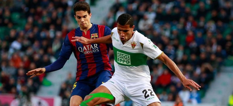 Barcelona's defender Marc Bartra (L) vies with Elche's Brazilian forward Jonathas Cristian de Jesus during the Spanish league football match Elche FC vs FC Barcelona at the Martinez Valero stadium in Elche on January 24, 2015. AFP PHOTO / JOSE JORDAN