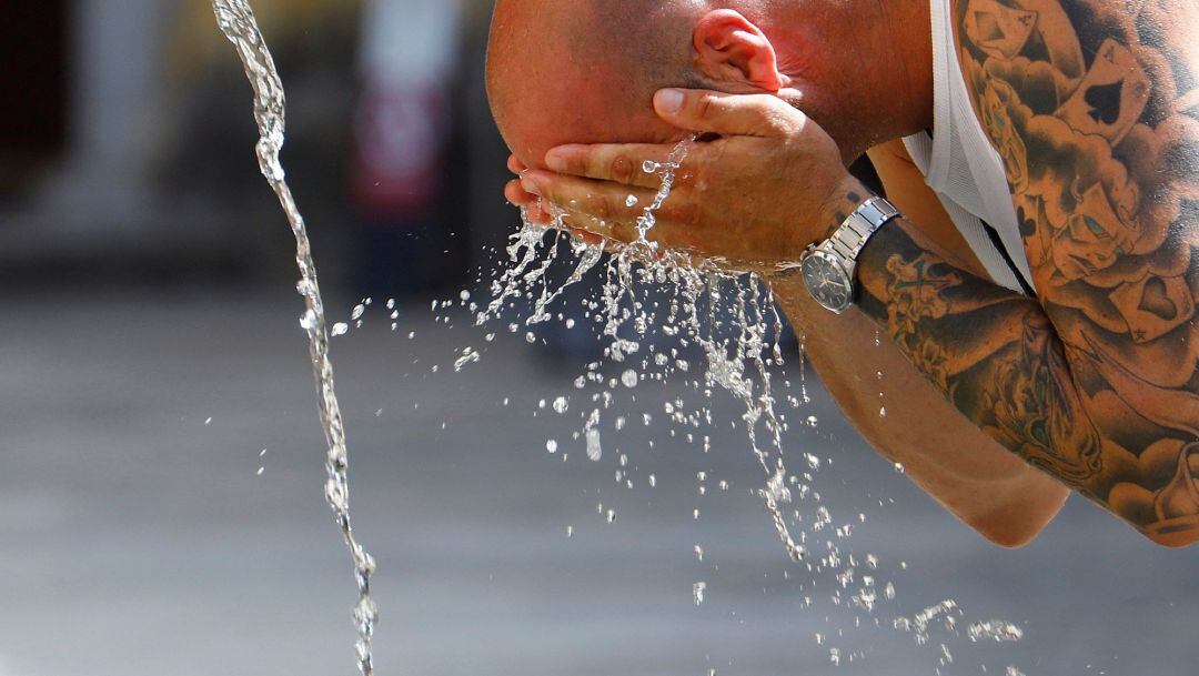 Un turista se refresca en el centro de Córdoba durante la ola de calor 