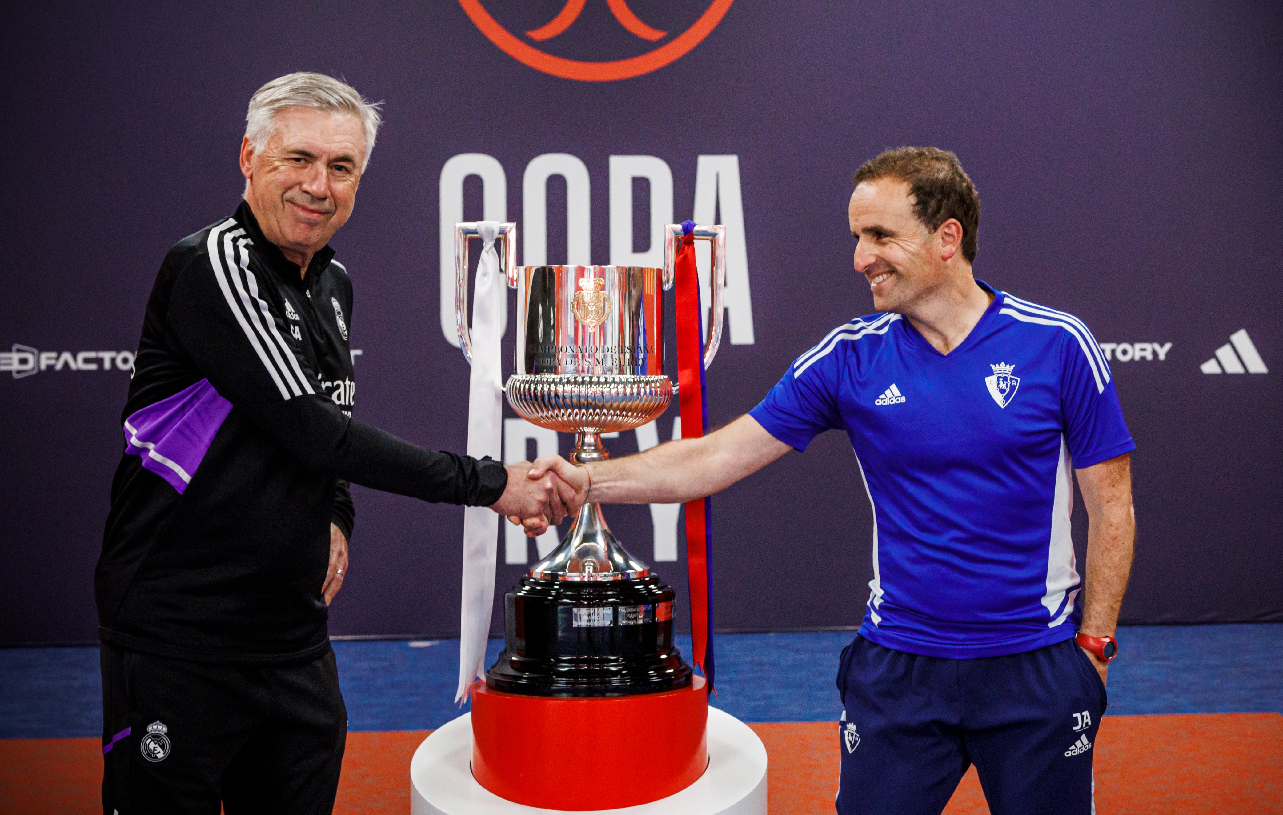 Los entrenadores del Real Madrid, Carlo Ancelotti, y de Osasuna, Jagoba Arrasate, se saludan ante el trofeo de la Copa del Rey.