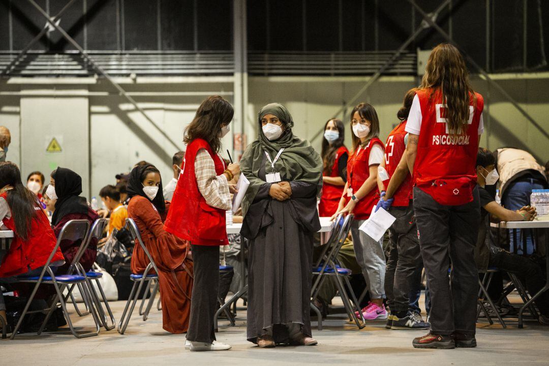 19-08-2021 Una trabajadora de Cruz Roja conversa con una de las mujeres repatriadas a España en el avión A400M tras su evacuación de Kabul, a 19 de agosto de 2021, en Torrejón de Ardoz, Madrid, (España). El avión, enviado por el Gobierno de España, ha rep