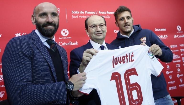 El futbolista Stevan Jovetic, junto al presidente del Sevilla FC, José Castro y el director deportivo, Monchi, durante su presentación oficial como nuevo jugador del Sevilla, en el estadio Sánchez Pizjuán.