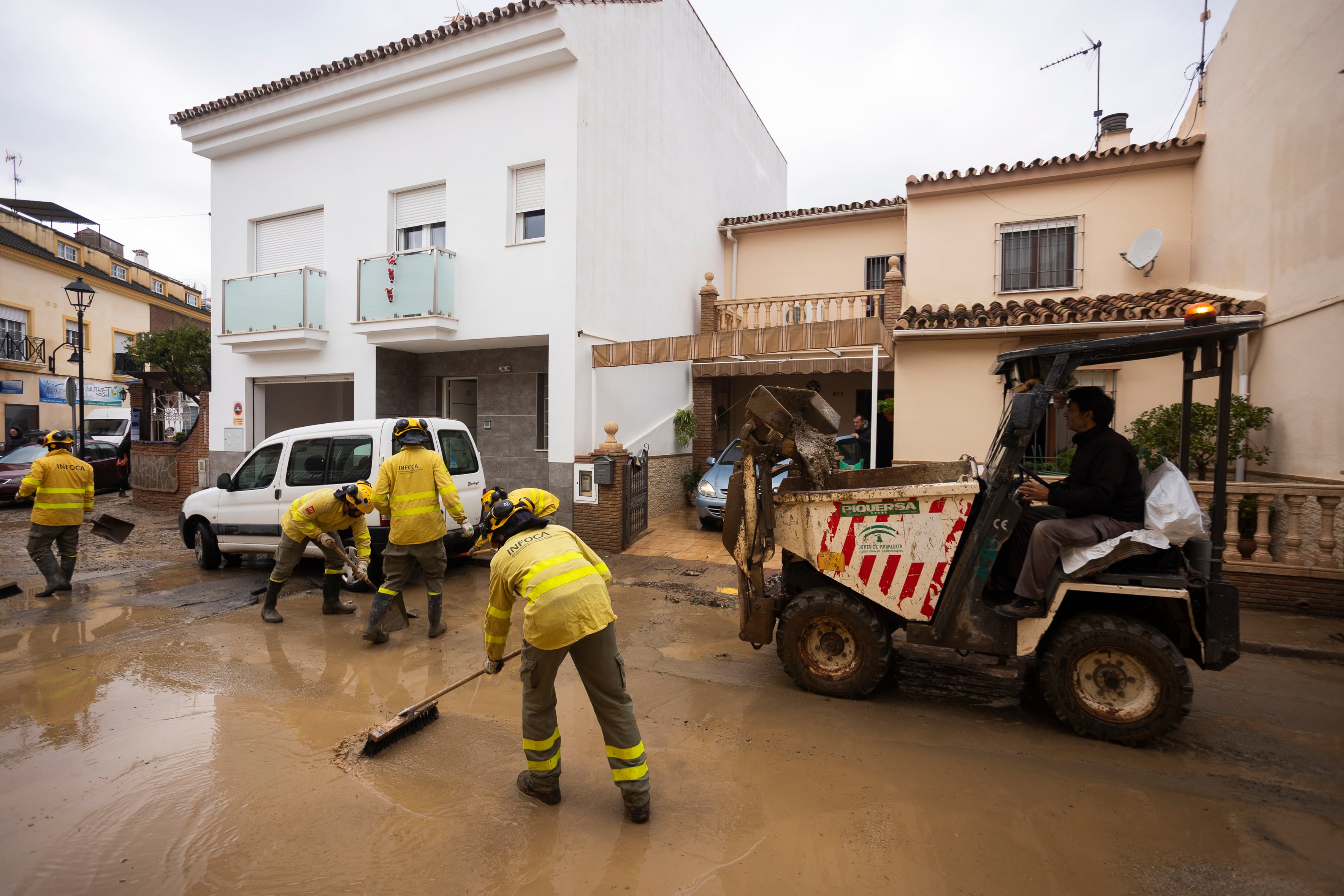 FOTODELDIA ESTACIÓN DE CÁRTAMA (MÁLAGA), 28/12/2025.- Efectivos de Infoca colaboran en las labores de limpieza de las calles este domingo en Estación de Cártama después de los problemas sufridos anoche en la localidad por la crecida del río Guadalhorce. El temporal de lluvia que afecta a Andalucía, principalmente a Málaga, ha dejado por el momento 304 incidencias en esta provincia, donde se han producido algunos desalojos y rescates en los municipios de Alhaurín de la Torre y Cártama por inundaciones. EFE/ Carlos Díaz