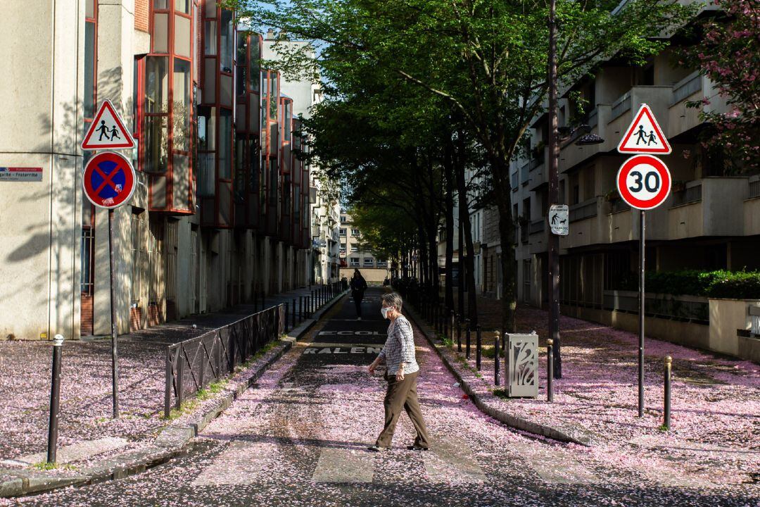 Mujer con mascarilla en una calle de París