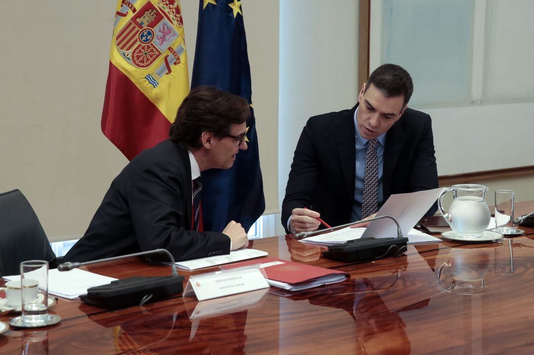 Fotografía facilitada por Moncloa que muestra al presidente del Gobierno, Pedro Sánchez (d) mientras conversa con el ministro de Sanidad, Salvador Illa (i) durante la videoconferencia de presidentes autonómicos 