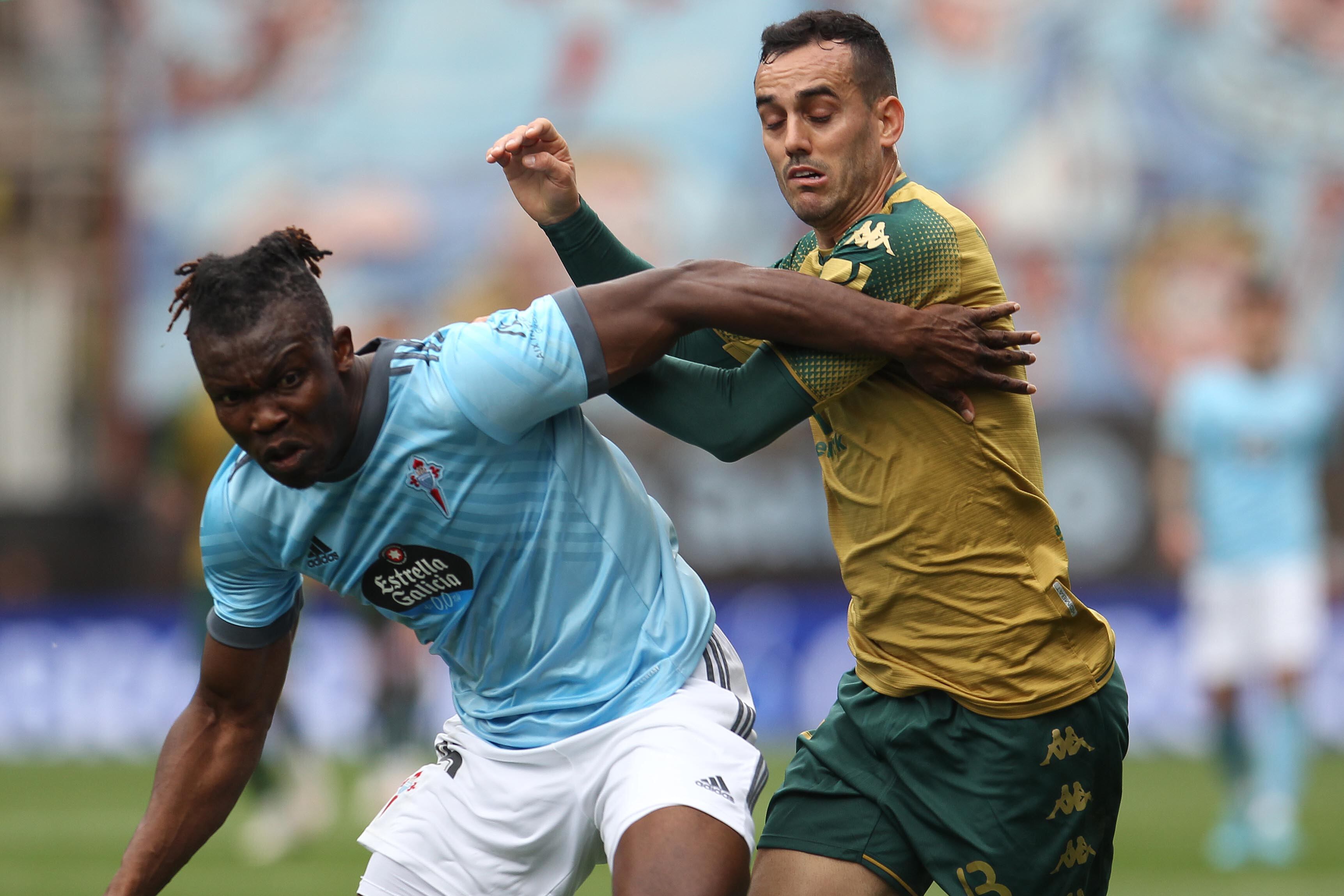 GRAF3085. VIGO, 20/03/2022.- El defensa ghanés del Celta de Vigo Joseph Aidoo (i) pugna por un balón con el delantero del Betis Juan Miguel Jiménez (d) durante el partido de Liga entre el Celta de Vigo y el Real Betis celebrado este domingo en el Estadio Balaídos de Vigo. EFE / Salvador Sas