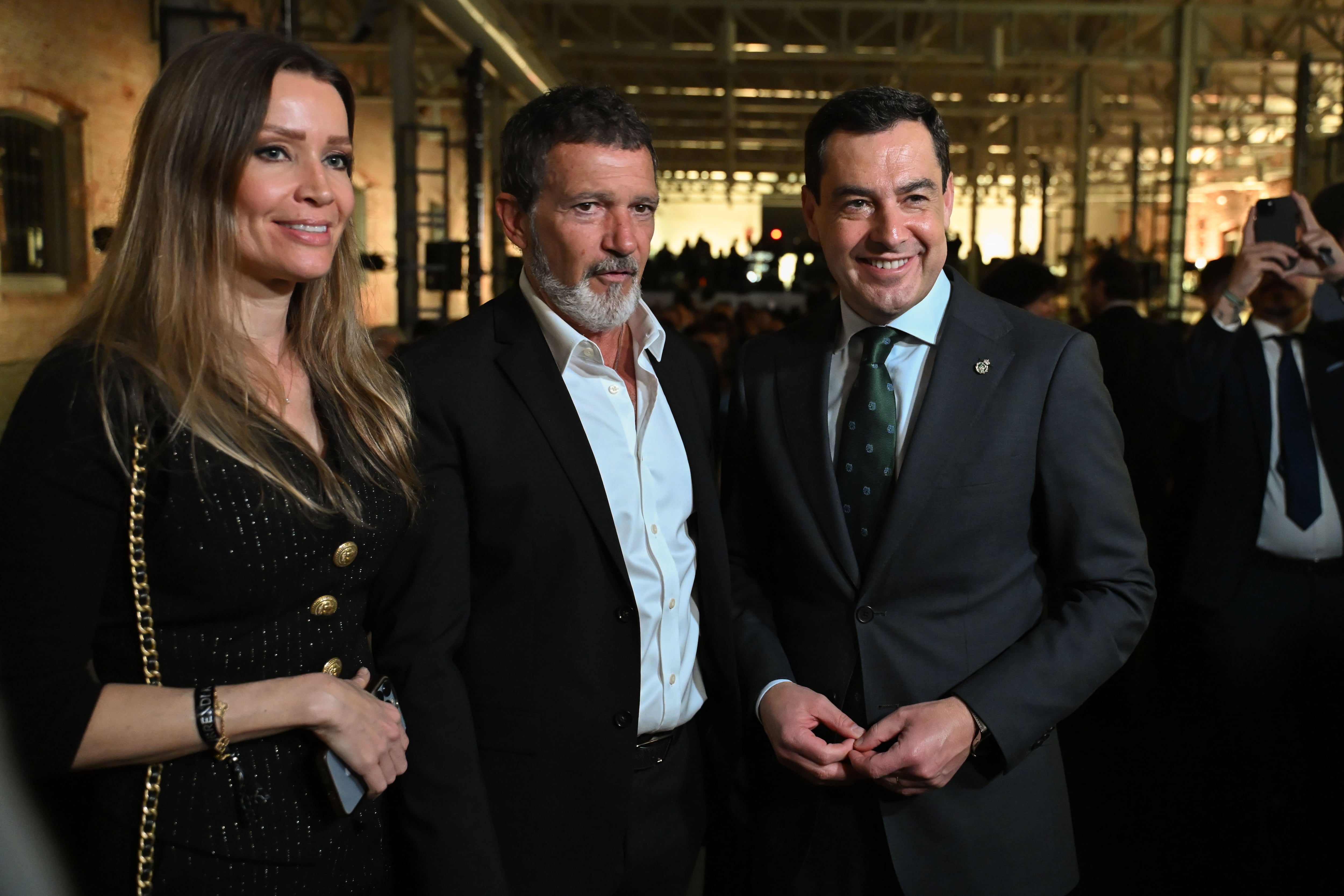 MADRID, 21/01/2025.- El presidente de la Junta Juanma Moreno (d), el actor Antonio Banderas (c) y su pareja Nicole Kimpel (i) asisten al acto promocional y networking profesional Surrender to the Andalusian Crush, campaña que rinde homenaje a la riqueza cultural y patrimonial de Andalucía, este martes en el Real Teatro de Retiro, en Madrid. EFE/Fernando Villar
