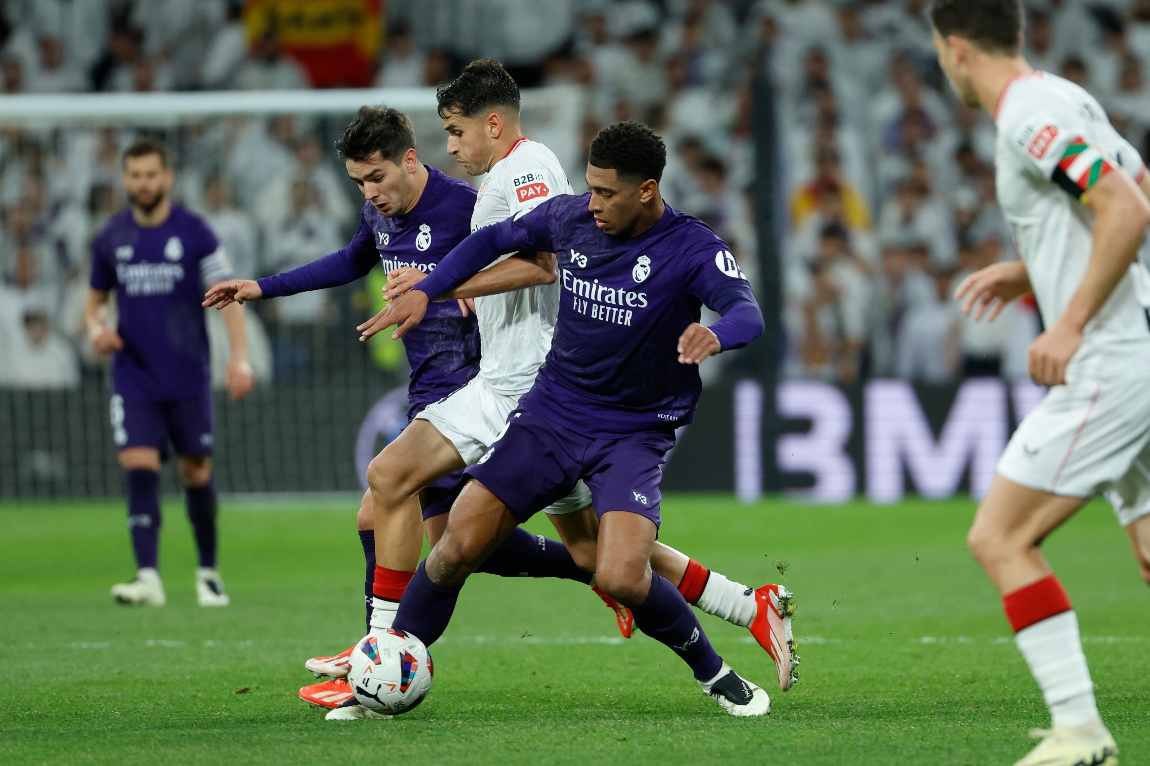 MADRID, 31/03/2024.- Los jugadores del Real Madrid Jude Bellingham (d) y Brahim Diaz (i) luchan con lucha con Beñat Prados, del Athletic Club, durante el partido de la jornada 30 de LaLiga que Real Madrid y Athletic Club de Bilbao disputan hoy domingo en el estadio Santiago Bernabéu, en Madrid. EFE/Mariscal
