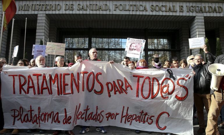 GRA040. MADRID, 27/12/2014.- Varias personas participan en una cadena humana, organizada por la Plataforma de Afectados por la Hepatitis C, rodeando el Ministerio de Sanidad para exigir tratamientos para la enfermedad.- EFE/Ballesteros