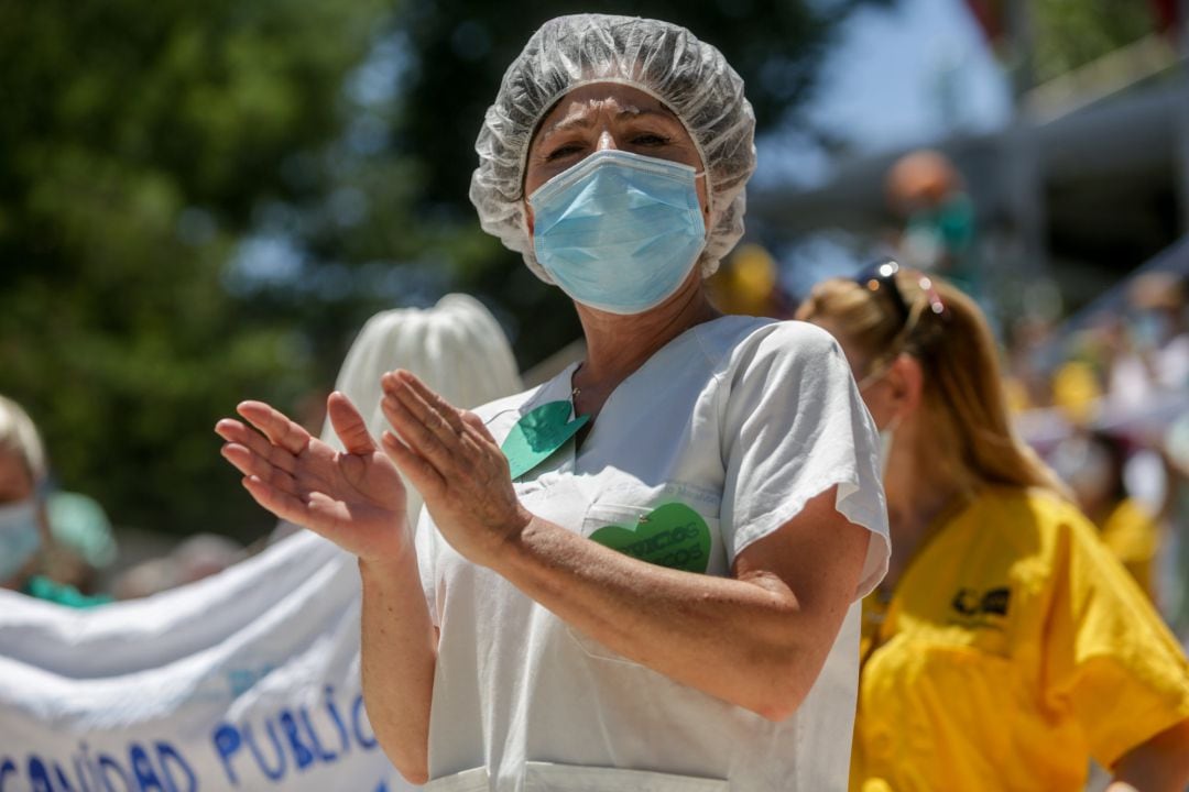 Una mujer aplaude durante la concentración convocada por las trabajadoras del servicio de limpieza del Hospital Gregorio Marañón de Madrid