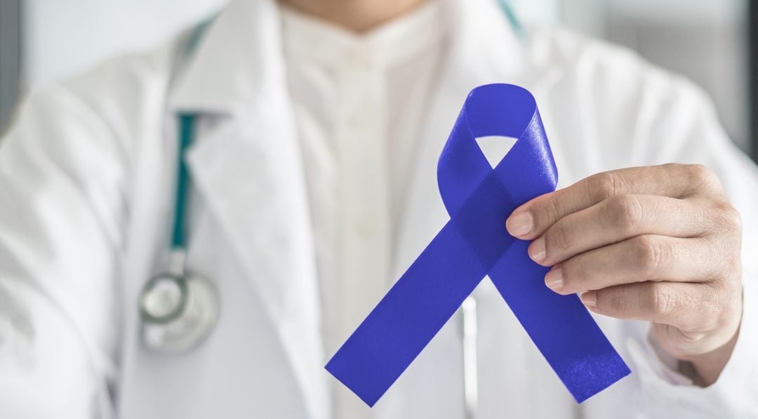 Un médico con el lazo azul que representa la lucha contra el cáncer de colon