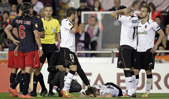 Los jugadores del Valencia CF reaccionan ante la lesión de su compañero Canales (en el suelo) durante el partido de vuelta de semifinales de la Liga Europa jugado este jueves en el Estadio de Mestalla ante el Atlético de Madrid