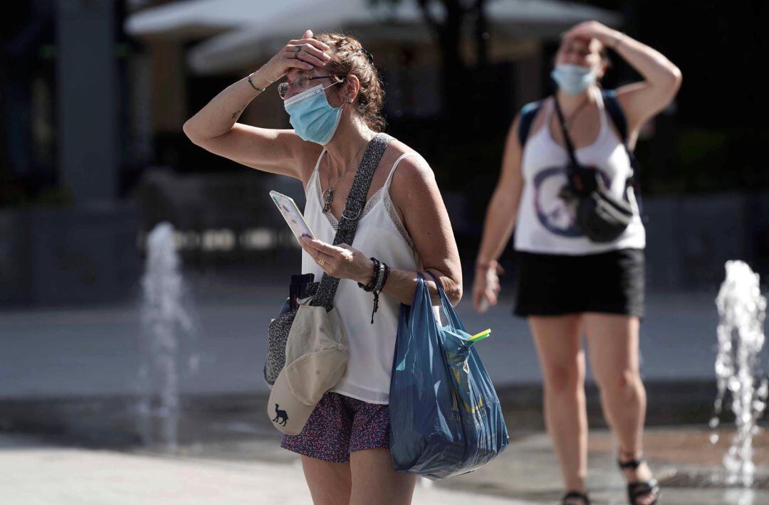Una mujer camina por una calle en una jornada con alerta por altas temperaturas