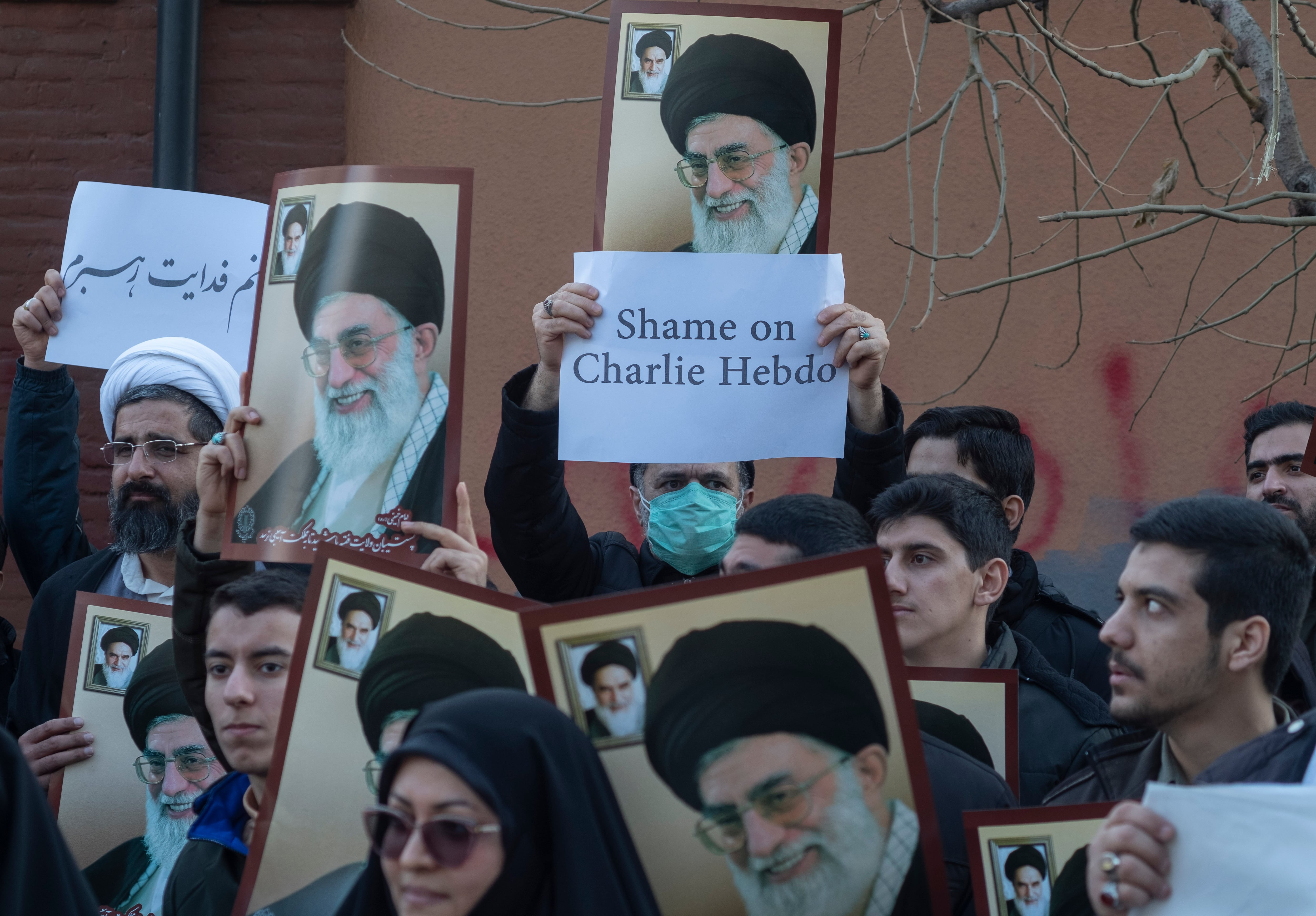 Manifestantes iraníes muestran el retrato del líder supremo, el Ayatollah Ali Khamenei y carteles contra &#039;Charlie Hebdo&#039;.