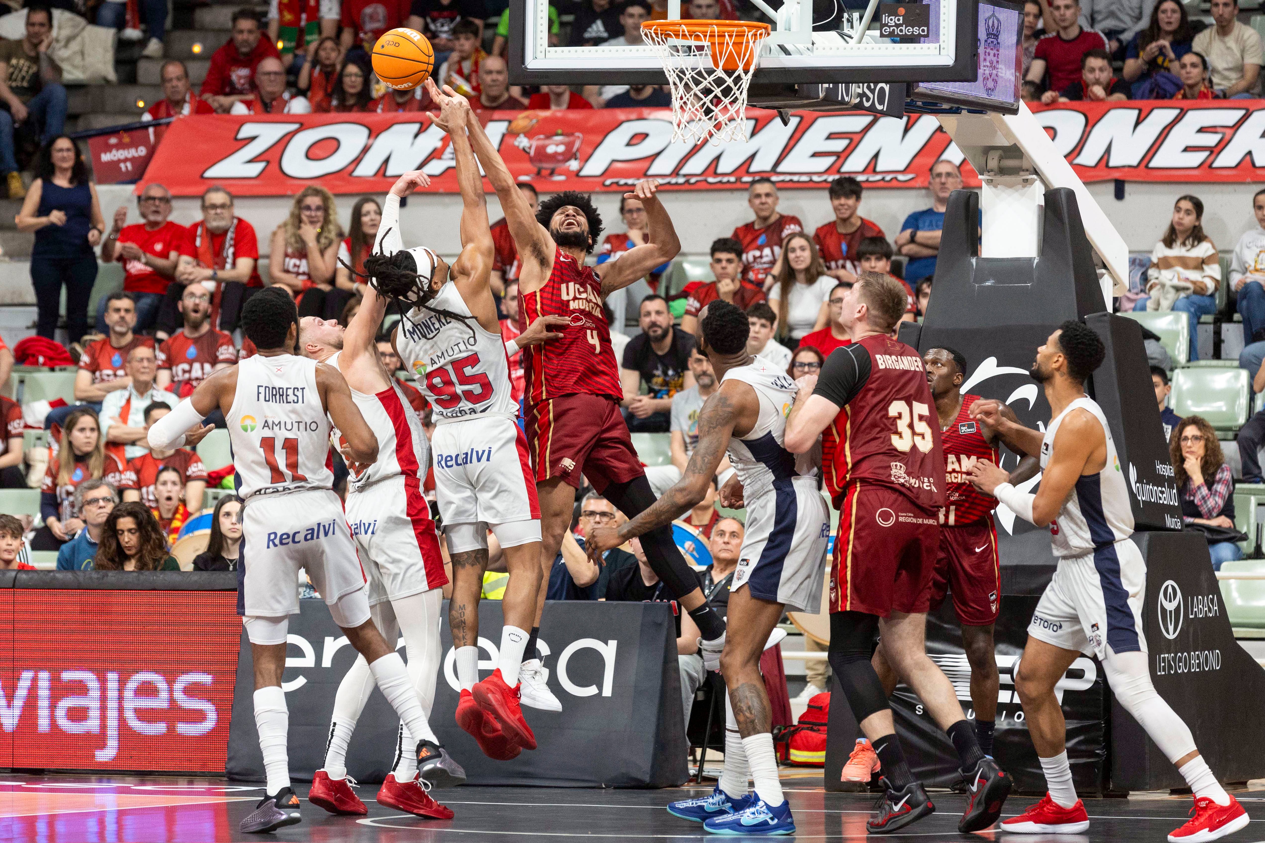 MURCIA, 12/04/2025.- El ala pívot estadounidense de UCAM Murcia Kaiser Gates (c) lucha por el balón con el ala pívot nigeriano del Baskonia Chima Moneke. EFE/Marcial Guillén