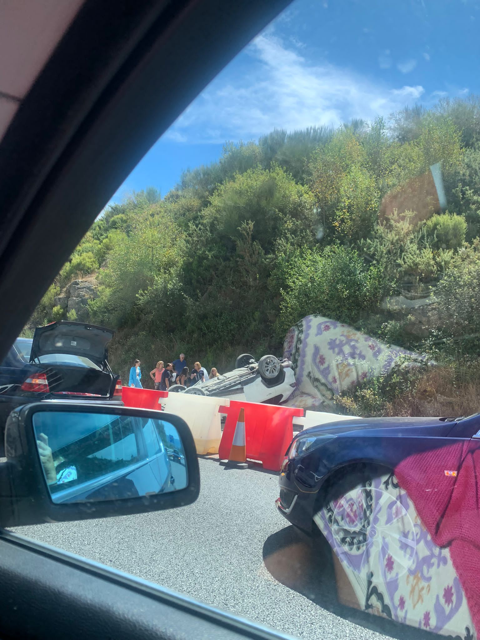 Imagen del coche volcado en el lateral de la A-52, desde un vehículo testigo del accidente