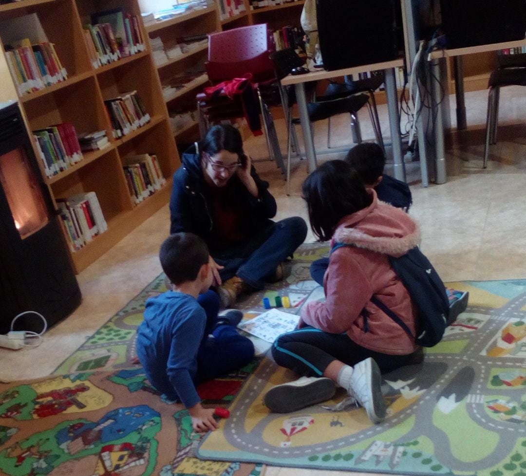 Varios niños participan en una actividad en la biblioteca de Navalmanzano