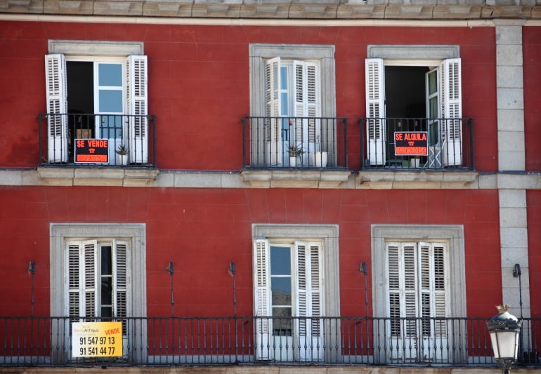 Carteles de &quot;Se vende&quot; y &quot;Se alquila&quot; en la fachada de un edificio.