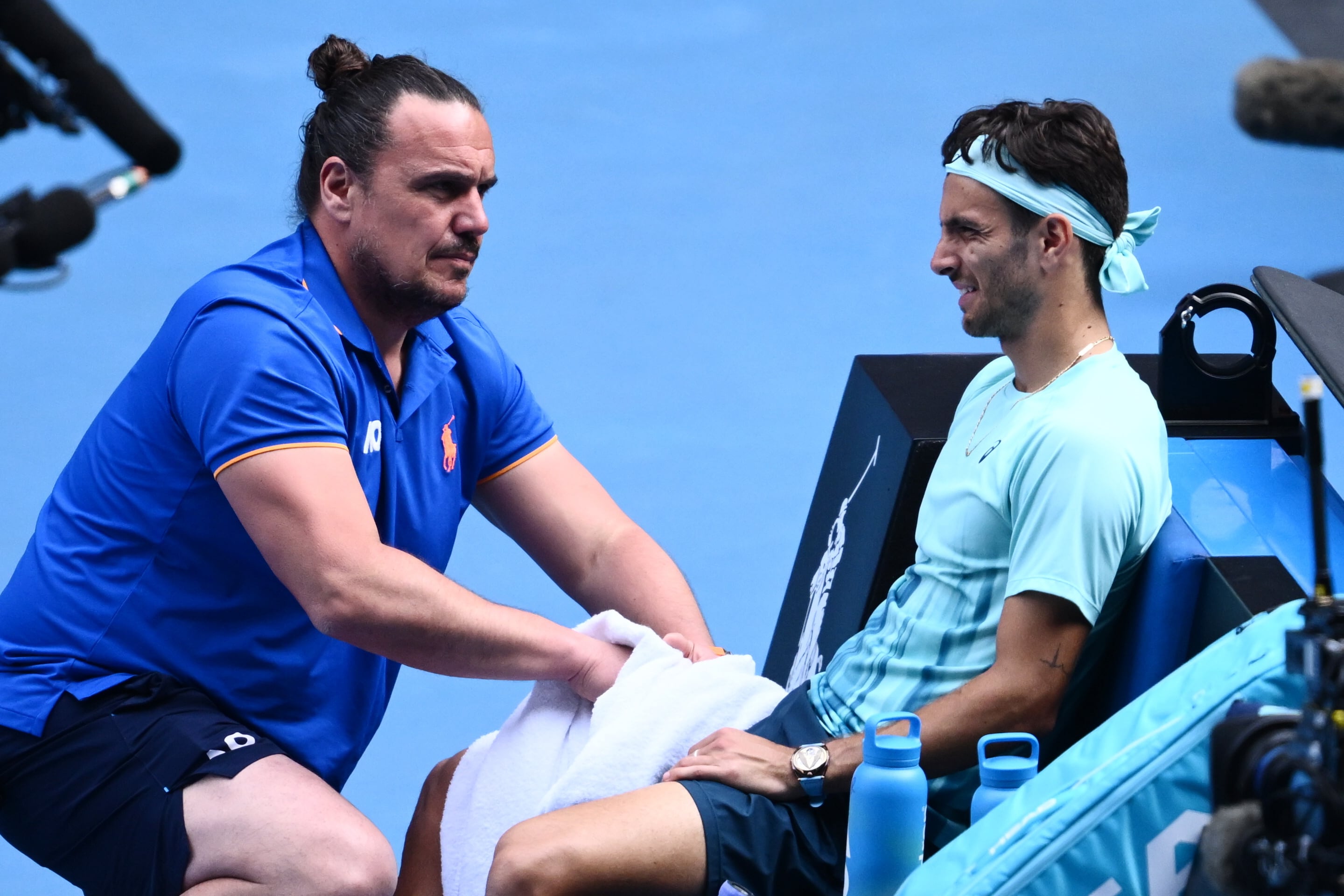 Lorenzo Musetti es asistido por sus médicos durante el partido contra Djokovic en Australia