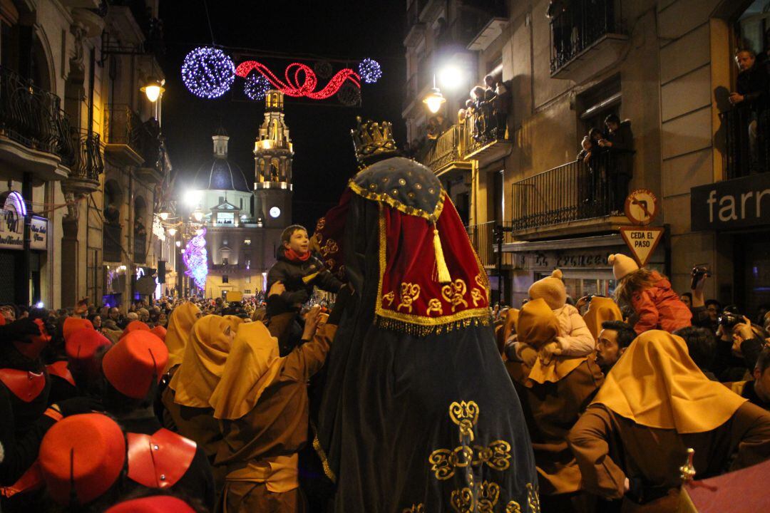 Un niño se acerca entre la multitud al rey Gaspar para besarlo en Alcoy