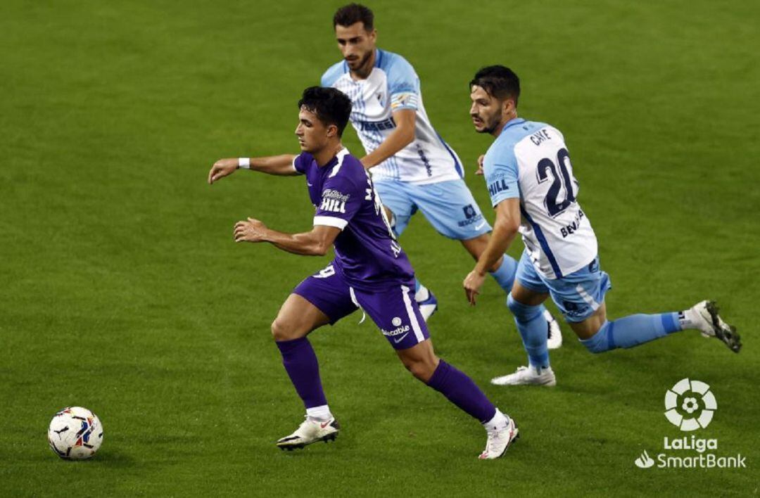 Manu García presionado por dos jugadores del Málaga.