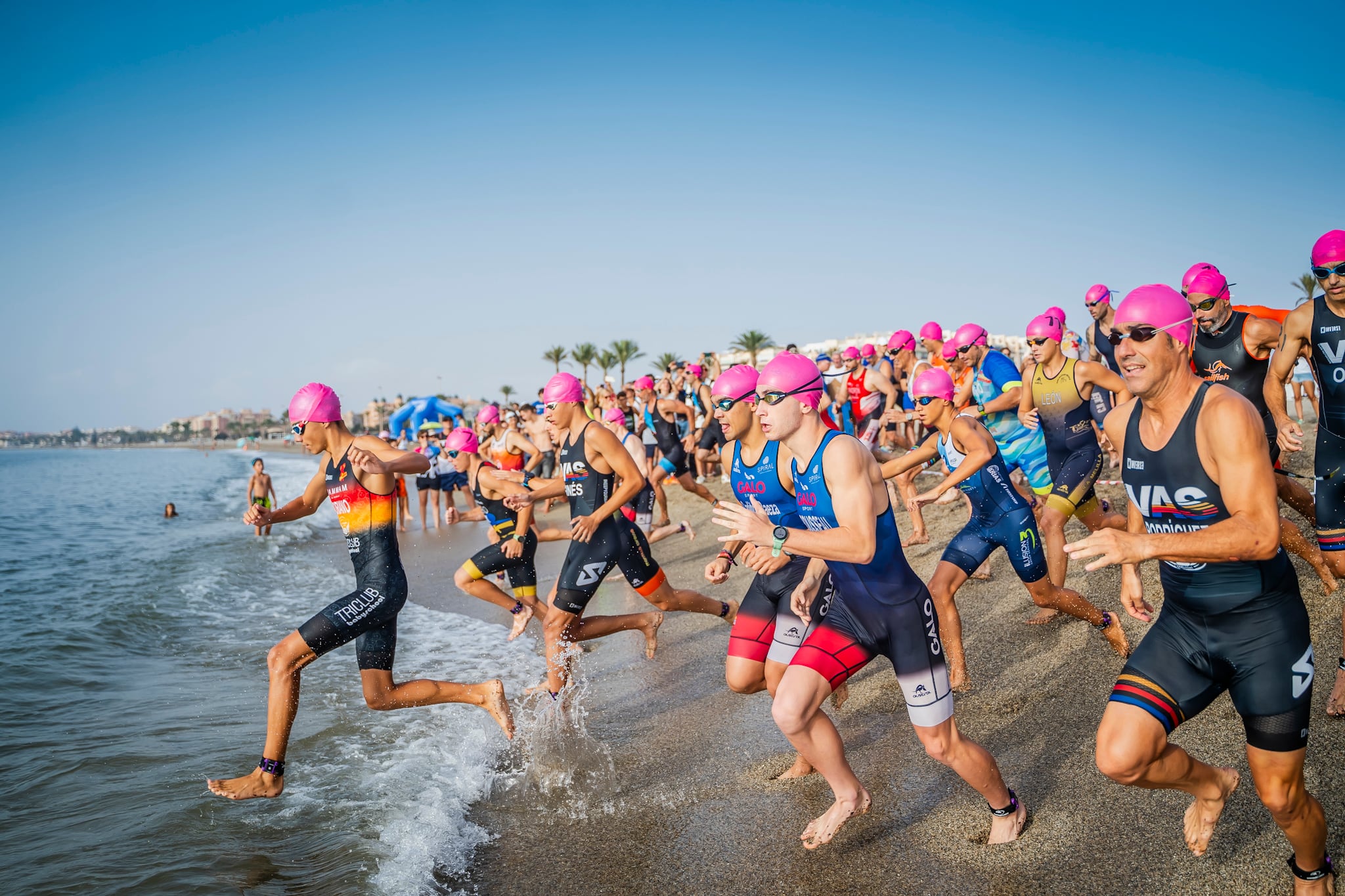 Los participantes del triatlón en su entrada al agua.