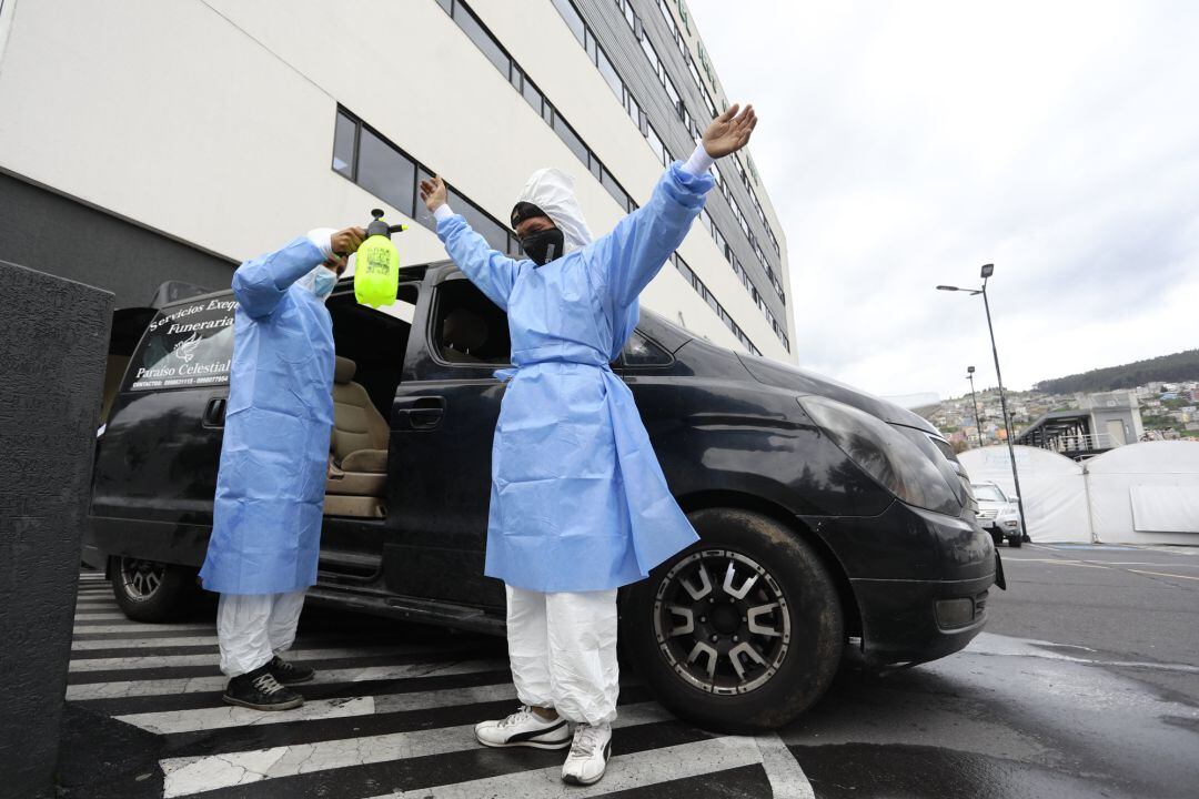 Trabajadores de una funeraria, frente a la morgue del Hospital IESS del Sur de Quito (Ecuador).